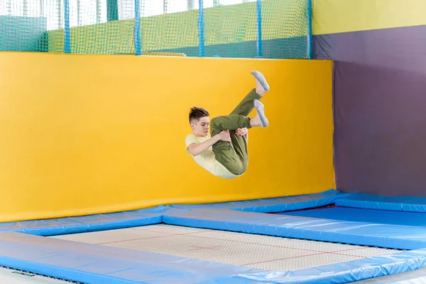 Nastolatek chłopiec skoków na trampolinie park w centrum sportu — Zdjęcie stockowe