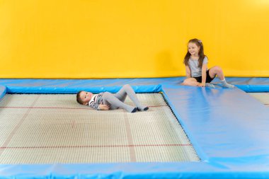 Eğlence merkezinde trambolinde zıplayan mutlu, küçük çocuklar.