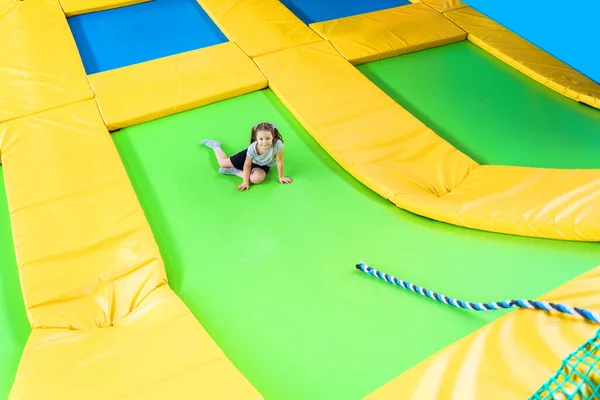 Niños jugando en el centro de trampolín saltando y escalando con cuerda — Foto de Stock