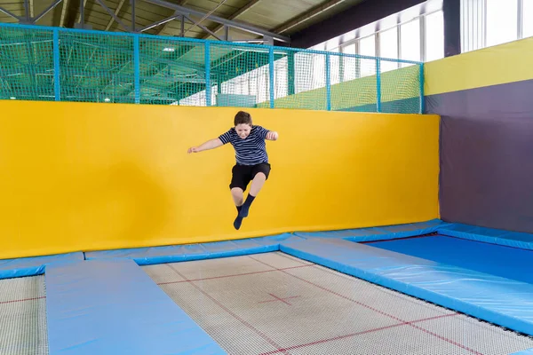 在一家儿童体育中心，一个体重增加的可爱小男孩在室内跳蹦床 — 图库照片