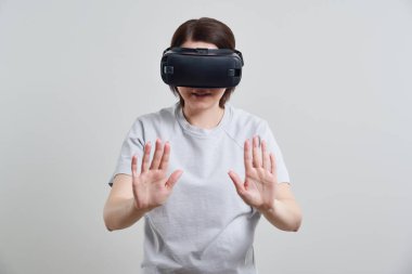 VR gözlükleriyle oynayan mutlu genç bir kadın, genç bir kızın kulaklıkla eğlendiği sanal gerçeklik konsepti, fotokopi alanı.