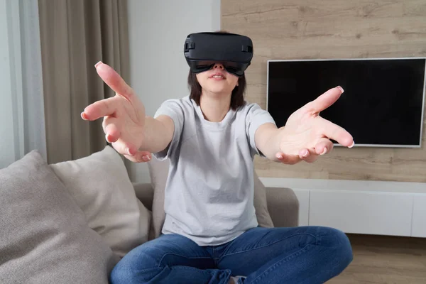 Wanita muda yang bahagia bermain dengan kacamata VR di dalam ruangan, konsep realitas virtual dengan gadis muda bersenang-senang dengan kacamata headset, dengan ruang fotokopi — Stok Foto