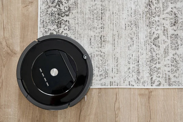 Aspirador robótico no chão na acolhedora sala de estar moderna — Fotografia de Stock