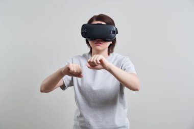 VR gözlükleriyle oynayan mutlu genç bir kadın, genç bir kızın kulaklıkla eğlendiği sanal gerçeklik konsepti, fotokopi alanı.