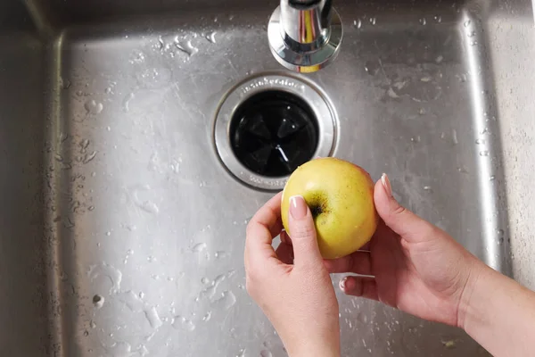 Donna che lava una mela nel lavandino della cucina — Foto Stock