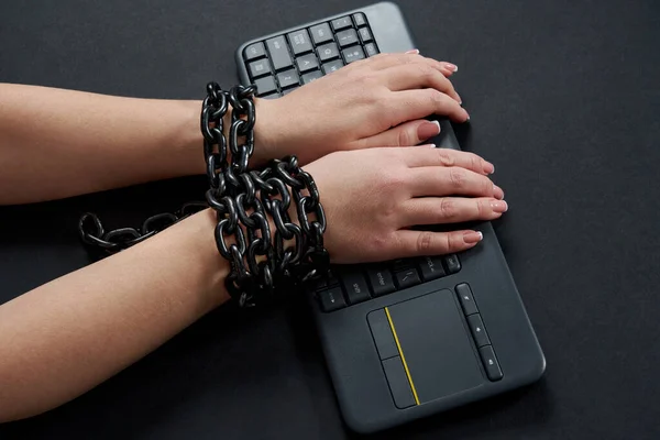 Female hands Chained to Keyboard, addiction concept