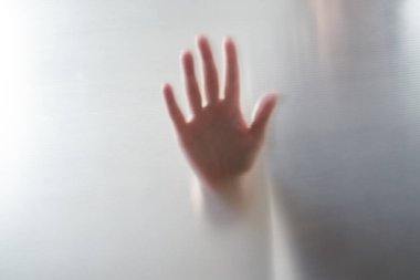 Kadın ellerinin dağınık silueti, plastiğin içinden gölgeli bir görüntü.