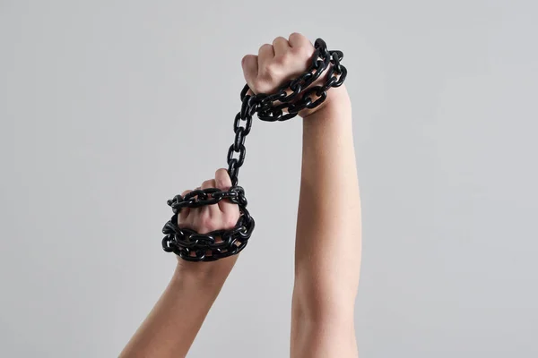 Руки женщины держат металлическую цепь над головой — стоковое фото