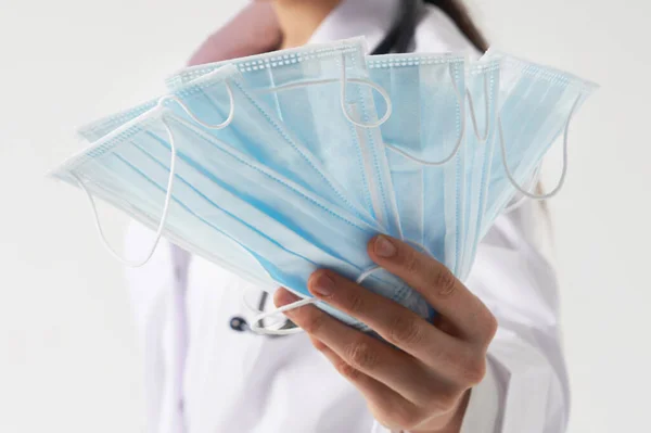 Doktor ya da hemşire, virüs enfeksiyonu, koronavirüs konseptini korumak için koruyucu yüz maskesi kullanmayı öneriyor.
