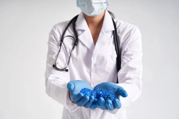 Врач держит в руках медицинские перчатки трехмерной синей модели вируса - коронавирус COVID-19 — стоковое фото