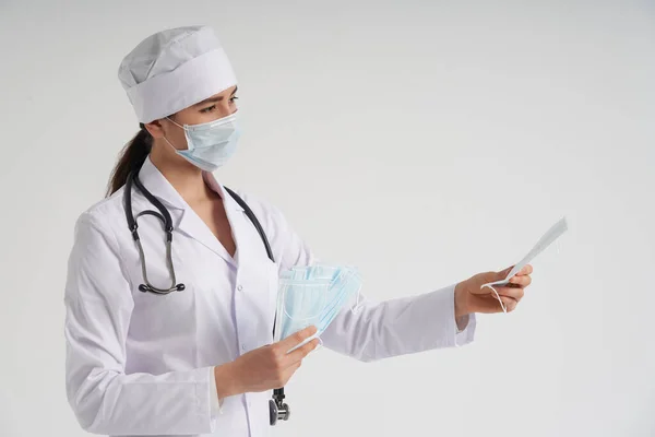 Läkare eller sjuksköterska rekommenderar att använda skyddande ansiktsmask för att skydda mot virusinfektion, coronavirus koncept — Stockfoto