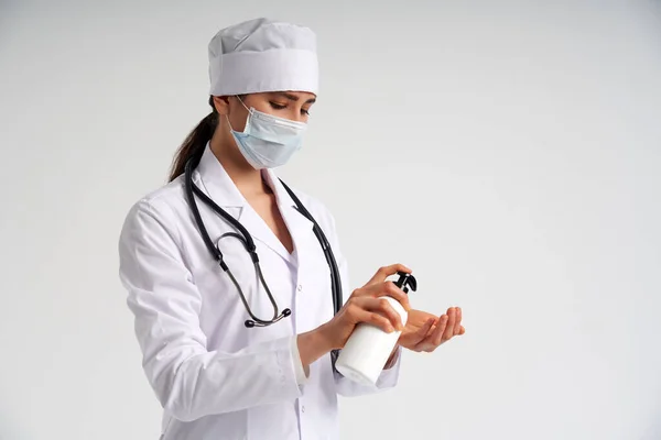 Läkare applicera antibakteriell spray på handen på vit bakgrund — Stockfoto