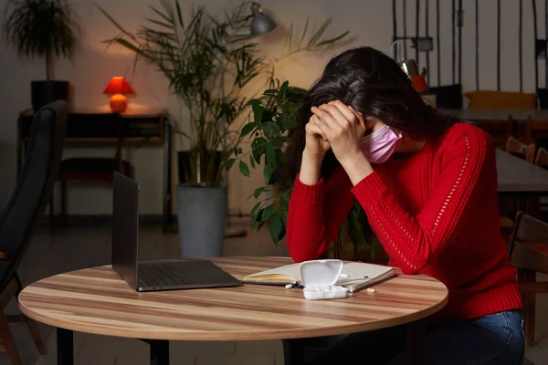 Mulher doente com pílulas e termômetro em uma mesa trabalhando em um laptop de casa em isolamento de quarentena . — Fotografia de Stock