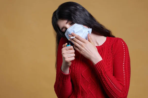 Menina vestindo máscara protetora médica acende-se, segurando um cigarro na boca através da máscara — Fotografia de Stock