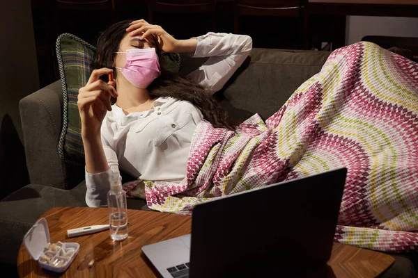 Kanepedeki genç kadın battaniyeyle örtülmüş, donarak burnu donuyor, ateşi var, hasta kız grip, grip ya da virüs belirtileri gösteriyor. — Stok fotoğraf