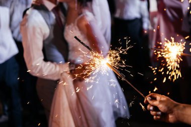 Düğündeki maytap, gelin, damat ve konukların elinde ışıklar.