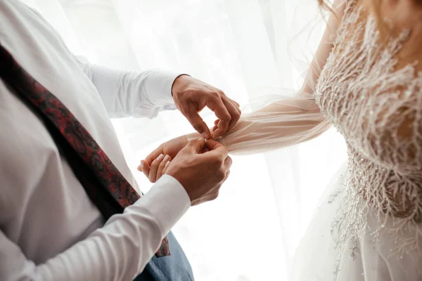 Pengantin pria membantu pengantin wanita dengan gaunnya, konsep romantis — Stok Foto