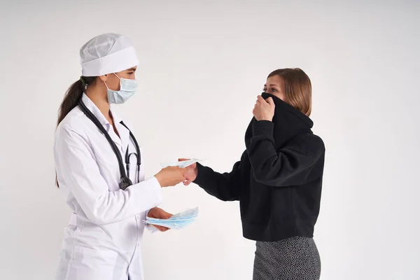 Врач дает пациенту защитную маску для защиты от вирусной инфекции, коронавирусной концепции — стоковое фото