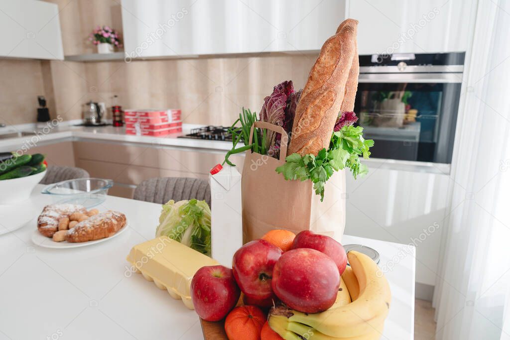 Paper bag with vegetables and bread, grocery with copy space on kitchen table