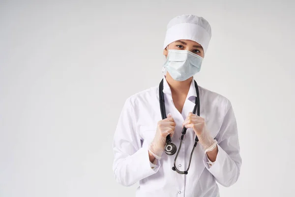 Молодая женщина-врач держит стетоскоп висит на шее, студия снимается на белом фоне с копией пространства — стоковое фото