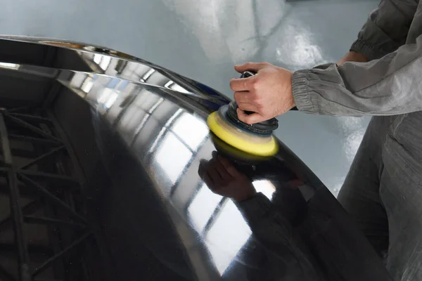 Zbliżenie pracownika rąk za pomocą polerki do polerowania szarego nadwozia samochodu w warsztacie, Auto mechaniczne polerowanie samochodu — Zdjęcie stockowe