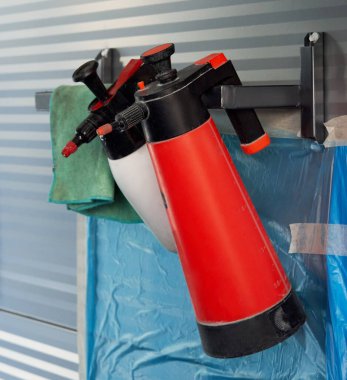 Araba tamirhanesinin duvarında asılı duran plastik şişeler.