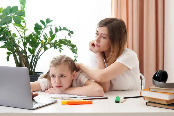 Anne, üzgün kızının ödevlerini yapmasına yardım ediyor. Karantinada evde eğitim kavramı. Uzaklık öğrenme zorluğu — Stok fotoğraf