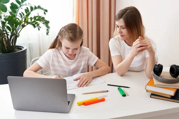 Anne, kızına ev ödevi için yardım ediyor. Karantinada evde eğitim kavramı. Uzaklık öğrenme zorluğu — Stok fotoğraf