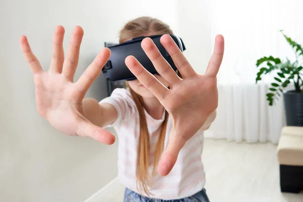 Дівчинка-підліток в гарнітурі окулярів віртуальної реальності і грає, коробка vr. технології, нове покоління, концепція прогресу. Дівчина намагається торкнутися об'єктів у віртуальній реальності . — стокове фото
