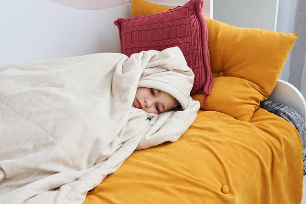 Cute sad girl in bed wrapped in soft blanket — Stock Photo, Image