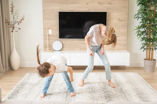 Zwei Schwestern haben Spaß beim Tanzen im Wohnzimmer, glückliches Familienkonzept — Stockfoto