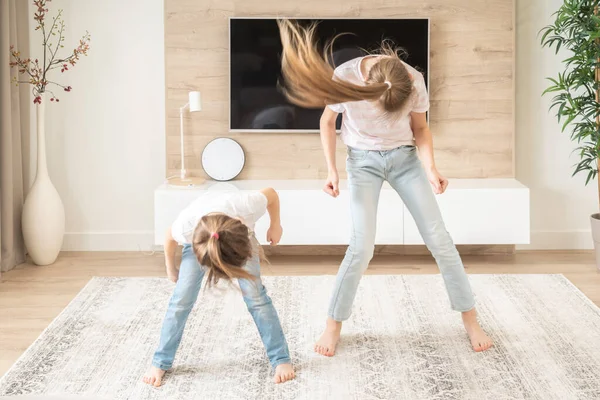 Two sisters having fun dancing in living room, happy family concept — Stock Photo, Image