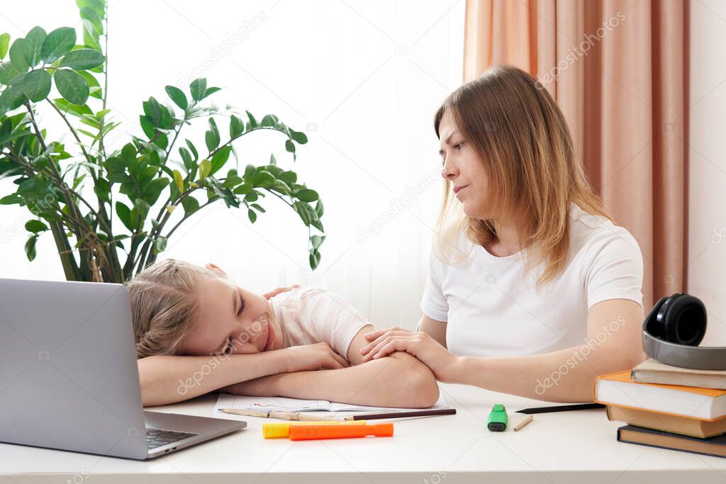 Mother helping sad daughter to do homework. The concept of home education in quarantine. Difficulties of distance learning