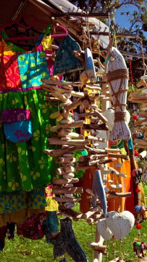 Arkasında parlak renklerde giysiler olan ahşap bir çelenk.