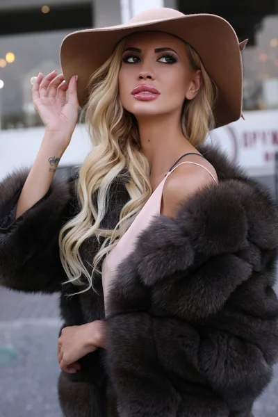 Mulher linda com cabelo loiro no luxuoso casaco de peles e chapéu — Fotografia de Stock