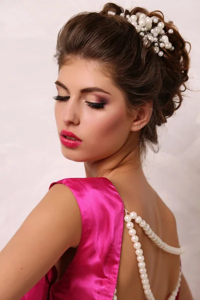 Menina bonita com cabelo escuro e maquiagem brilhante em vestido elegante — Fotografia de Stock