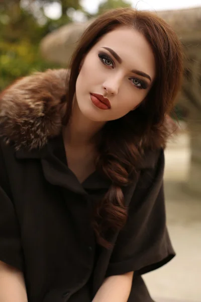 Schitterende sensuele vrouw met donker haar in elegante kleding en luxe jas, — Stockfoto