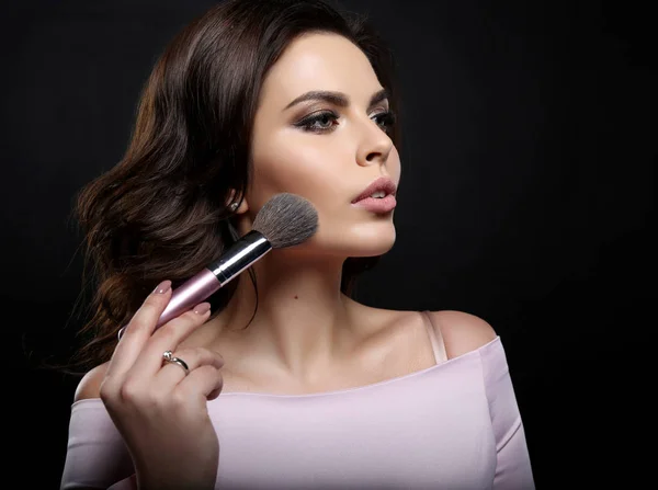 Gorgeous woman with dark hair finishing her makeup using powder — Stock Photo, Image