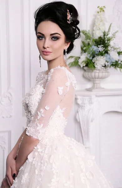 Великолепная невеста с темными волосами в роскошном свадебном платье — стоковое фото