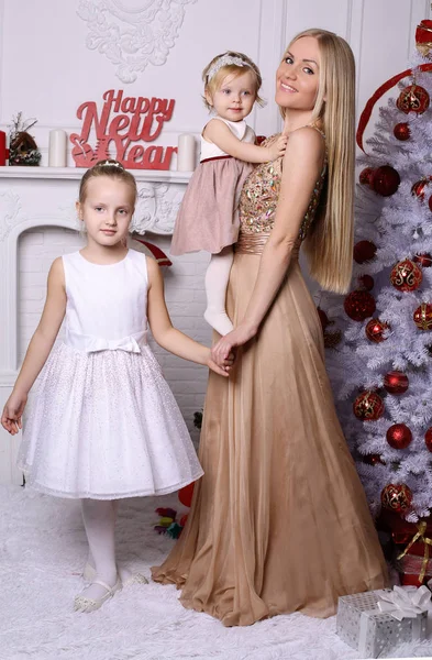 Prachtige moeder met lang blond haar, poserend met schattige schattige dochters — Stockfoto