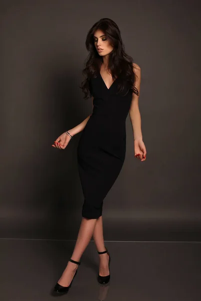 Hermosa mujer con el pelo largo oscuro posando en el estudio en negro dre —  Fotos de Stock