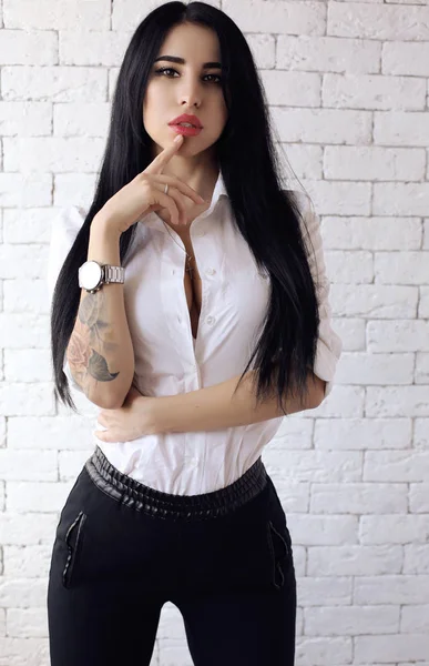 Schönes Mädchen mit dunklen Haaren in lässiger Kleidung posiert im Studio — Stockfoto
