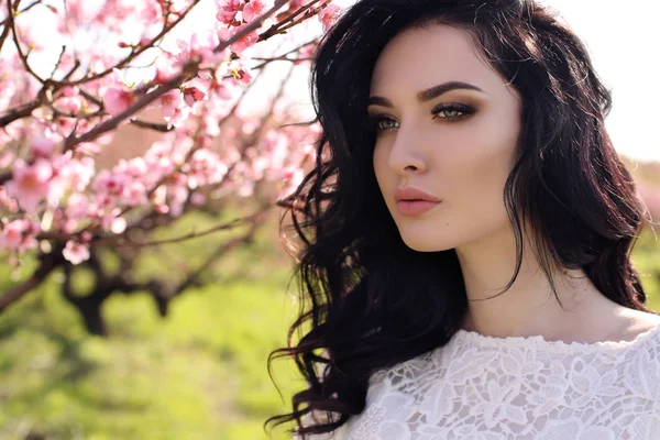 Wspaniała młoda kobieta elegancka sukienka pozowanie w ogrodzie z drzewami kwiat brzoskwini — Zdjęcie stockowe