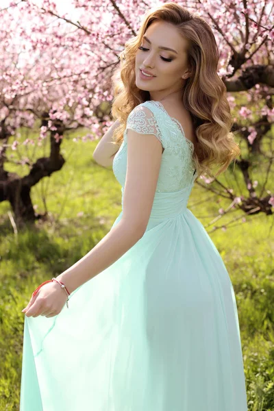 Blosso içinde poz şık elbiseli sarışın saçlı güzel kadın — Stok fotoğraf