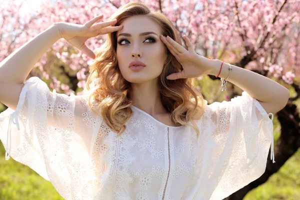 Hermosa mujer con el pelo rubio en vestido elegante posando en flor — Foto de Stock