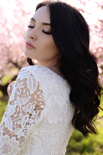 Zarif elbise blossom bahçede poz koyu saçlı kadın — Stok fotoğraf