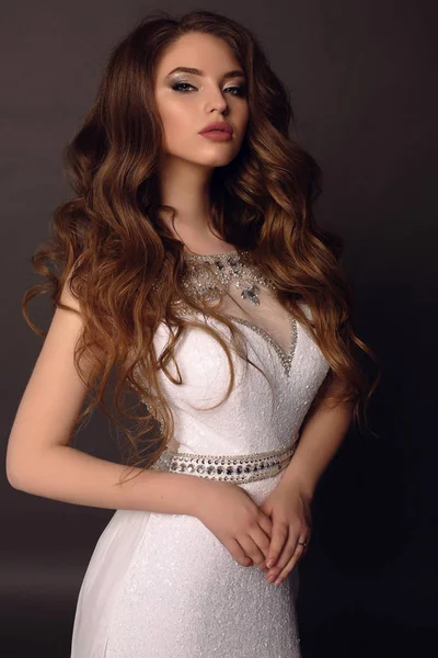Belle jeune femme aux cheveux foncés en robe luxueuse — Photo