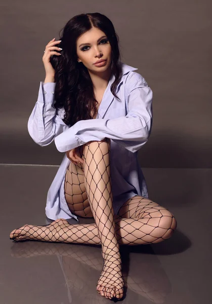 Gorgeous sexy woman with dark hair in shirt posing at studio — Stock Photo, Image