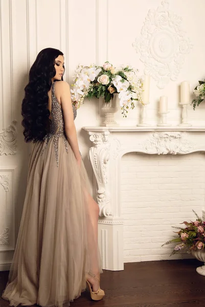 Wunderschöne Frau mit dunklen Haaren in luxuriösem Kleid — Stockfoto