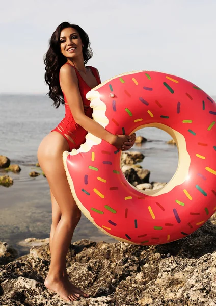 Sexig kvinna med långt mörkt lockigt hår iklädd bikini och beach cl — Stockfoto